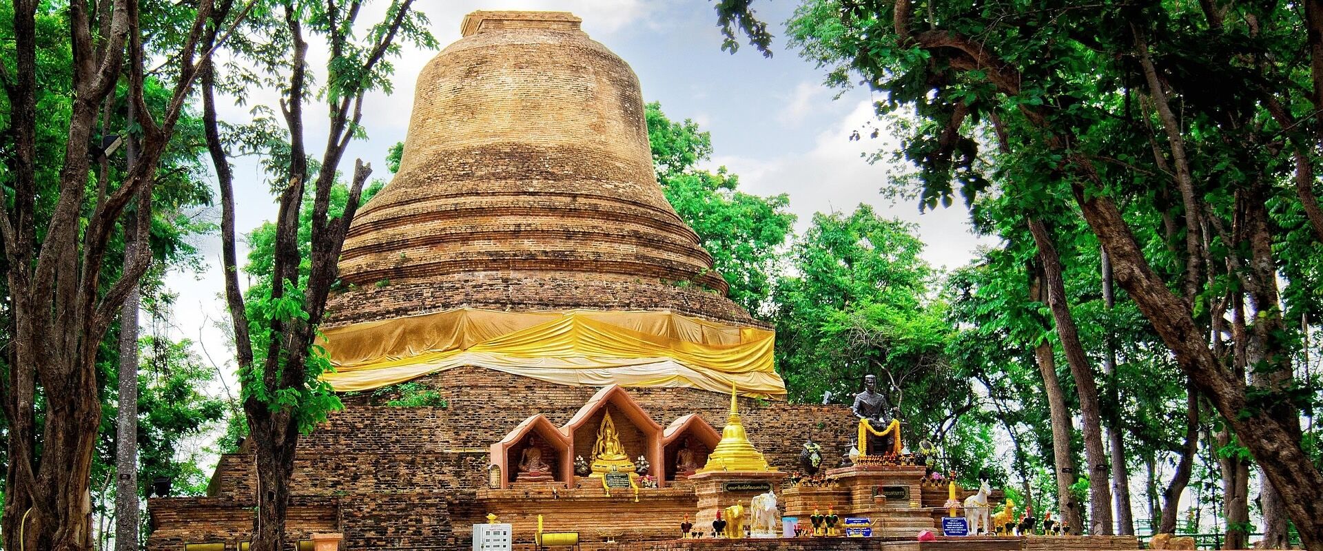 Iconic Phitsanulok temple against lush greenery on a Phitsanulok Travel guide banner by Legend Travel Group.